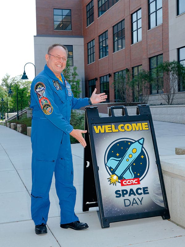 Col Edward Michael Fincke gesturing towards a sign for CCAC Space Day