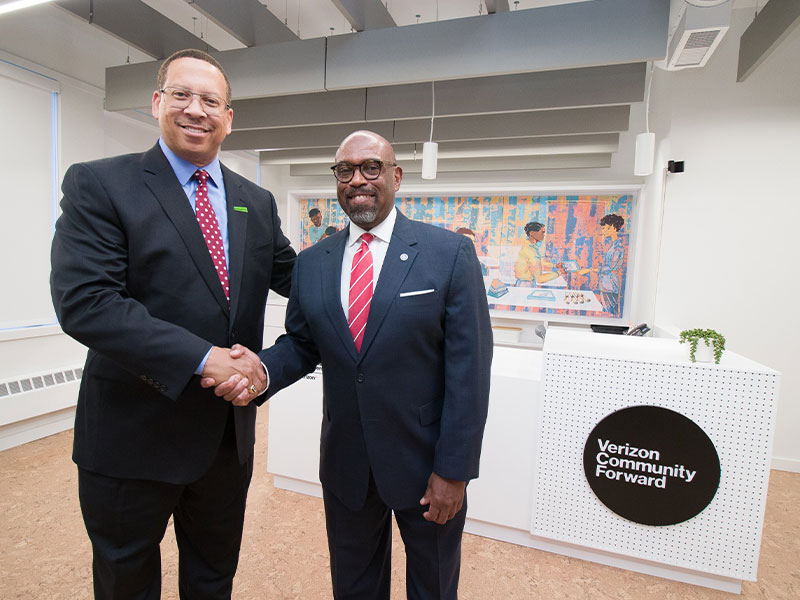 Presley Gillespie, president and CEO of Neighborhood Allies, and Dr. Quintin Bullock, president of CCAC, shake hands at the entrance to the new Verizon Community Forward Homewood-Brushton Adult Learning Center.