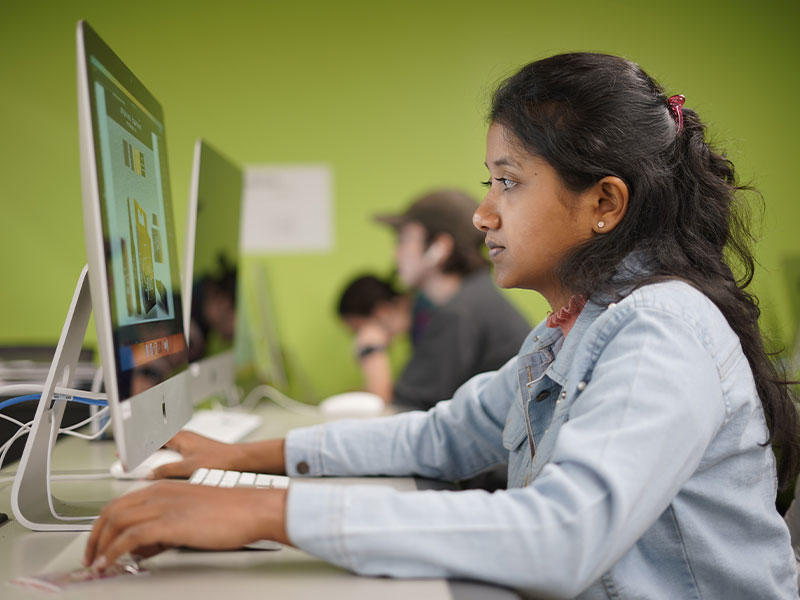 A CCAC graphic design student works at a computer in one of the college's media labs.